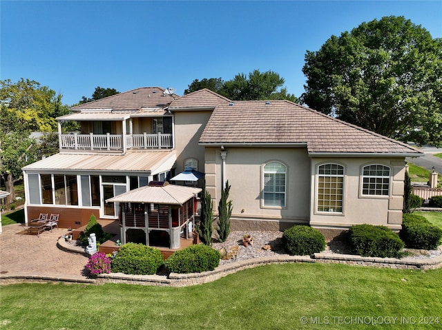 back of house featuring a balcony, a yard, and a patio