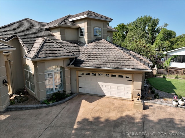 front of property with a garage and a front lawn