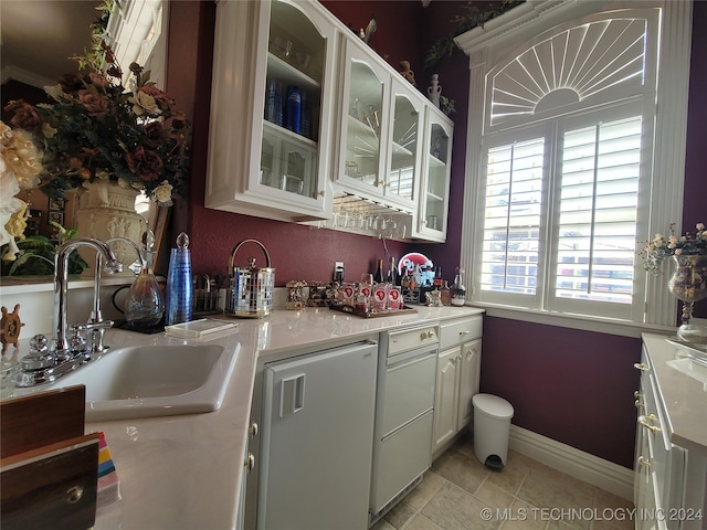 kitchen with sink, white cabinetry, and light tile patterned flooring