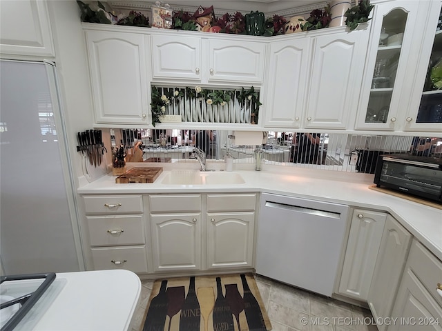 kitchen with white fridge, sink, white cabinetry, and stainless steel dishwasher