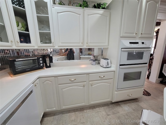 kitchen with white appliances, white cabinetry, and tasteful backsplash