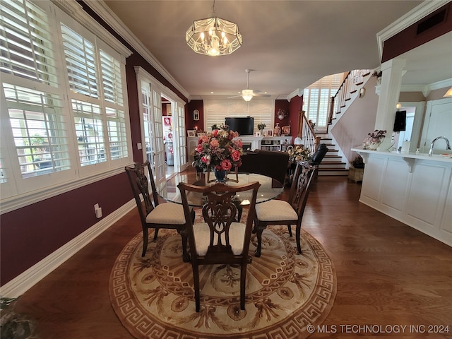 dining room with crown molding, dark wood-type flooring, sink, and ceiling fan with notable chandelier