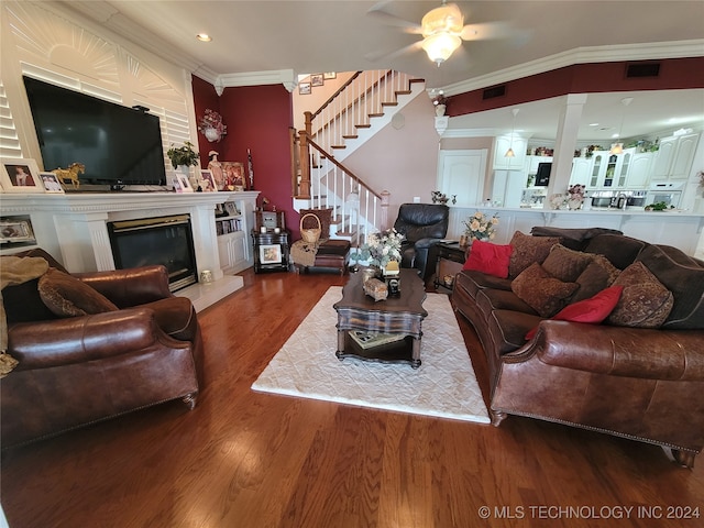 living room with ornamental molding, wood-type flooring, and ceiling fan