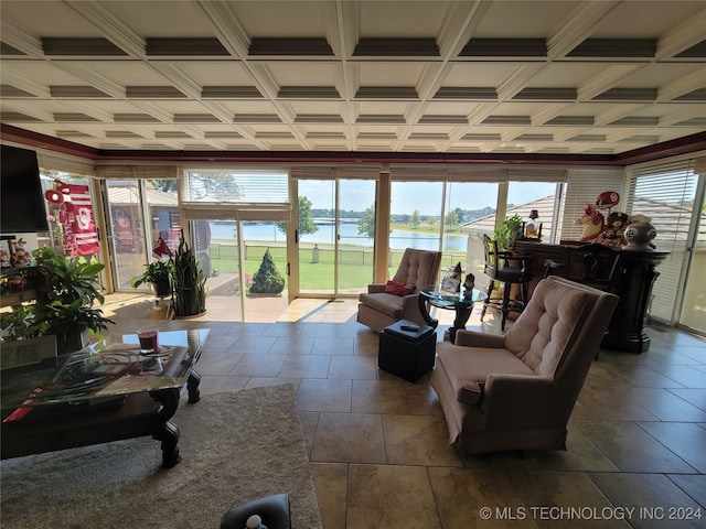 living room with a water view, crown molding, and a healthy amount of sunlight