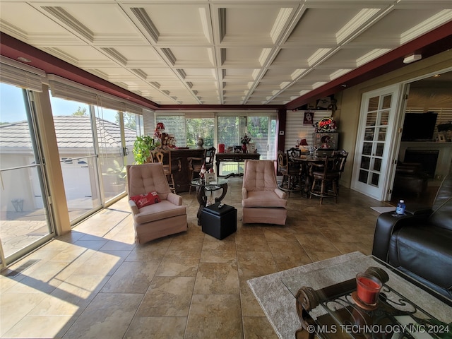 living room featuring coffered ceiling and plenty of natural light