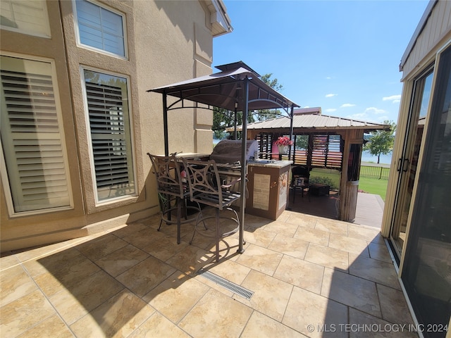 view of patio featuring a bar and a gazebo