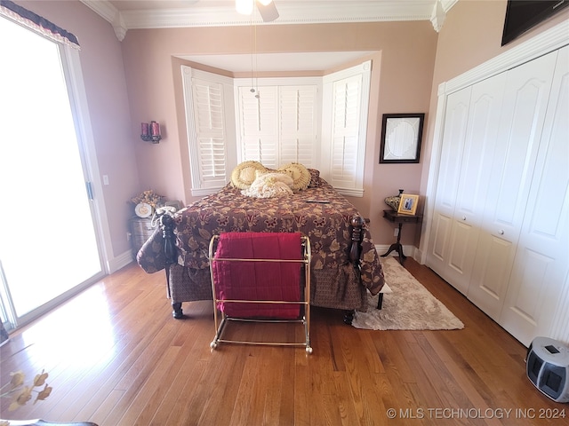 bedroom with ornamental molding, wood-type flooring, and ceiling fan