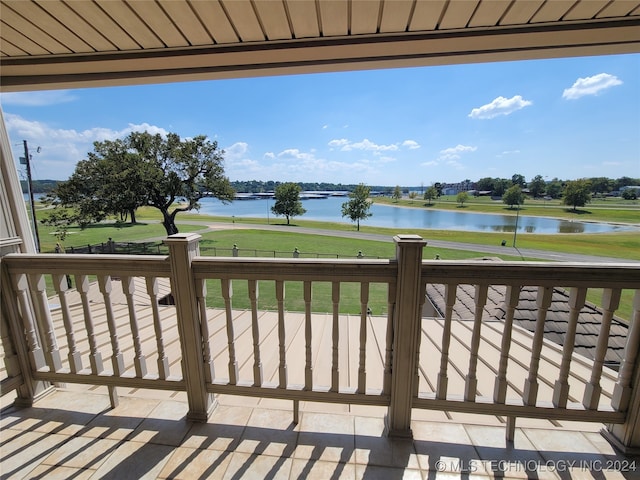 wooden terrace with a lawn and a water view