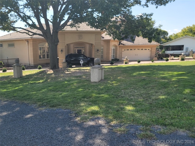 view of front of property with a front lawn and a garage