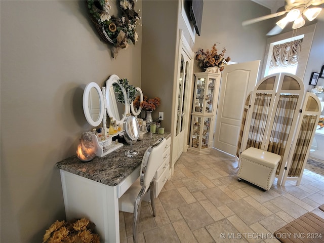 interior space featuring ceiling fan and a high ceiling