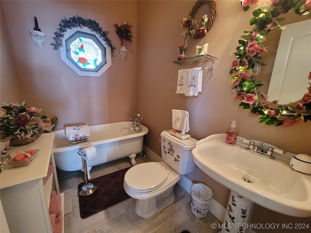 bathroom featuring tile patterned flooring, toilet, sink, and a bathtub