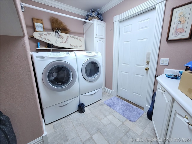 washroom with crown molding, washer and clothes dryer, and cabinets