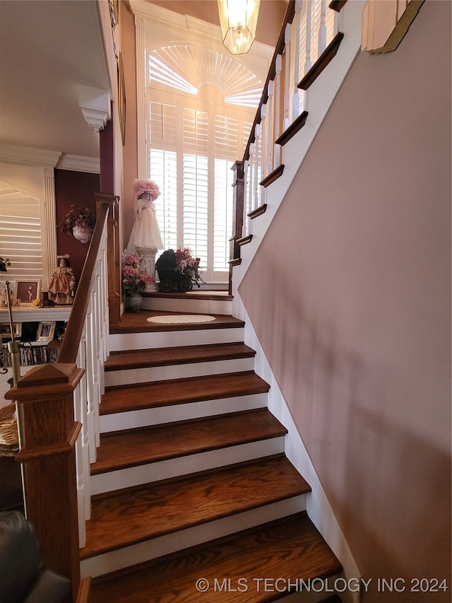 stairway featuring hardwood / wood-style floors and an inviting chandelier