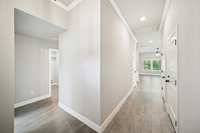 hallway featuring ornamental molding and light hardwood / wood-style flooring