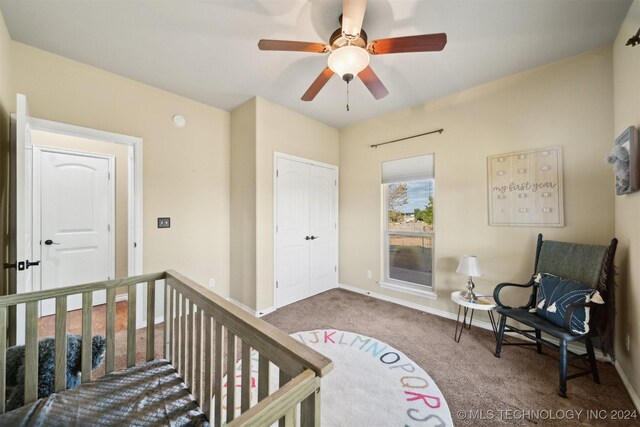 bedroom with ceiling fan, a closet, carpet floors, and a crib