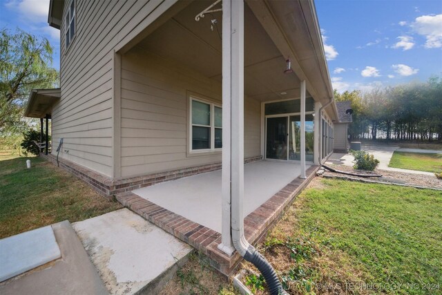 view of side of home with a lawn, cooling unit, and a patio