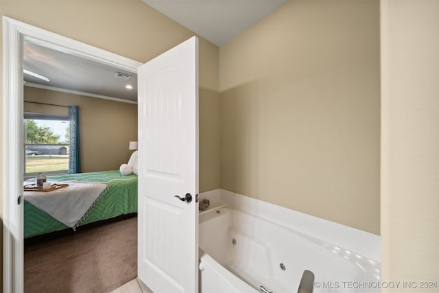 bathroom featuring ornamental molding and a bathing tub