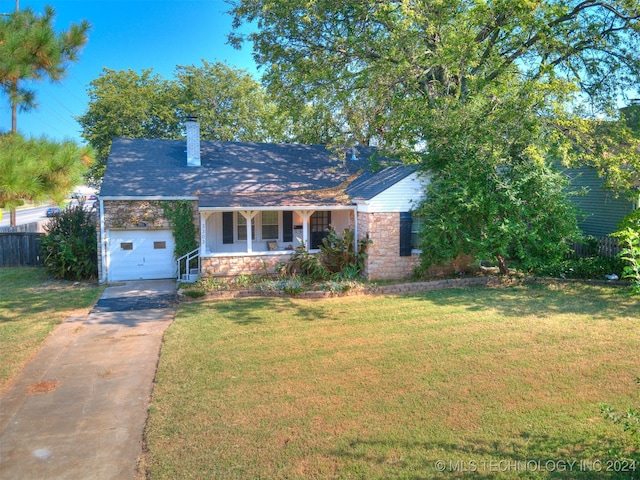 view of front of property with a garage, a front yard, and covered porch