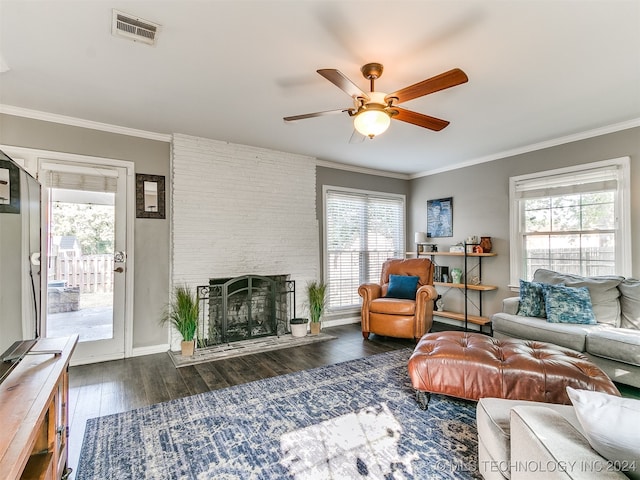 living room featuring dark hardwood / wood-style floors, ornamental molding, a large fireplace, and ceiling fan