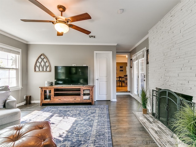 living room featuring ceiling fan, hardwood / wood-style flooring, a fireplace, and ornamental molding