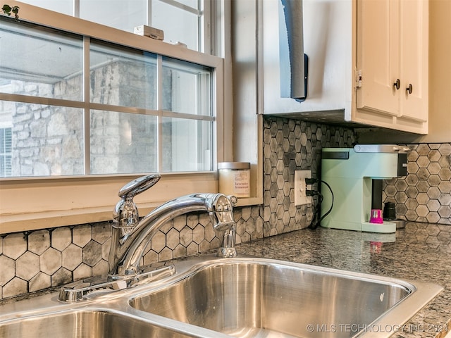 kitchen featuring sink, white cabinets, and decorative backsplash