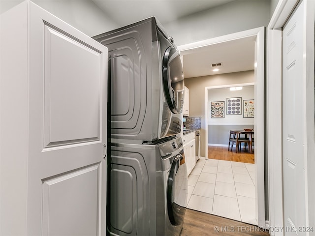 washroom featuring stacked washing maching and dryer and light hardwood / wood-style floors