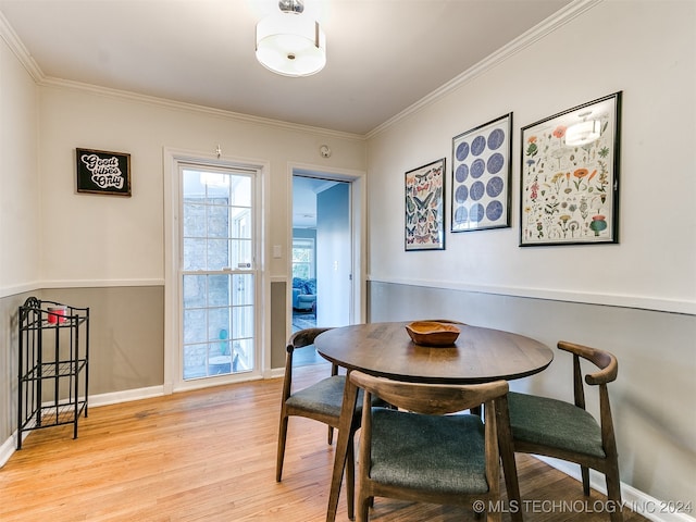 dining room featuring crown molding and light hardwood / wood-style flooring