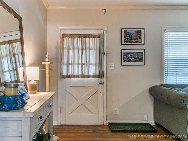 entryway with dark wood-type flooring and ornamental molding