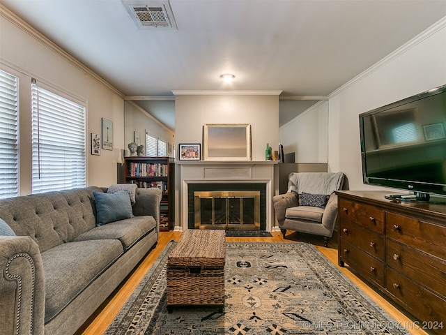 living room with crown molding and light hardwood / wood-style flooring