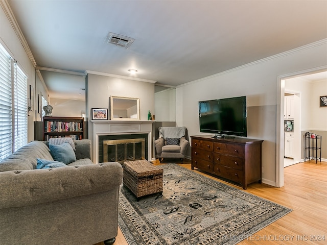 living room with crown molding, a wealth of natural light, and light hardwood / wood-style floors