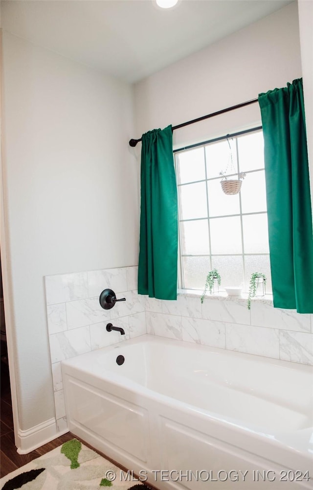 bathroom featuring wood-type flooring and a tub