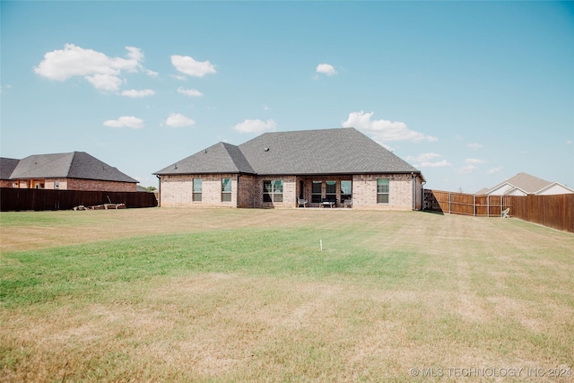 rear view of house featuring a lawn