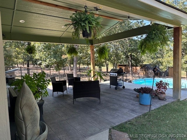 view of patio featuring a fenced in pool and grilling area