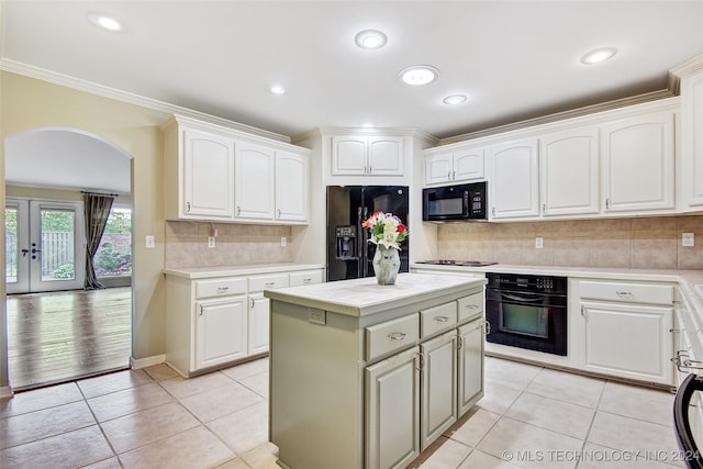 2116 E 59th Pl Unit 4F, Tulsa, OK 74105 - kitchen with black appliances, arched walkways, light countertops, ornamental molding, and white cabinetry