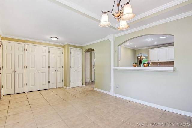 2116 E 59th Pl Unit 4F, Tulsa, OK 74105 - interior space featuring arched walkways, ornamental molding, a chandelier, and light tile patterned floors