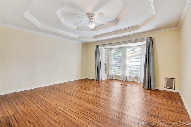 2116 E 59th Pl Unit 4F, Tulsa, OK 74105 - empty room featuring a tray ceiling, light wood finished floors, a ceiling fan, and ornamental molding
