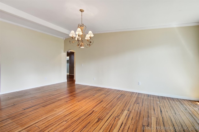 2116 E 59th Pl Unit 4F, Tulsa, OK 74105 - empty room with arched walkways, a chandelier, hardwood / wood-style flooring, and crown molding