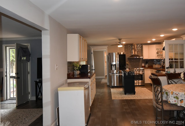 kitchen with appliances with stainless steel finishes, dark hardwood / wood-style floors, wall chimney exhaust hood, and decorative backsplash