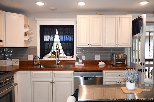 kitchen featuring white cabinets, appliances with stainless steel finishes, and decorative backsplash