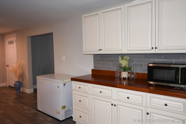 kitchen featuring white cabinetry, fridge, dark hardwood / wood-style flooring, and tasteful backsplash