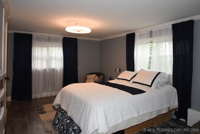 bedroom with dark hardwood / wood-style flooring and crown molding