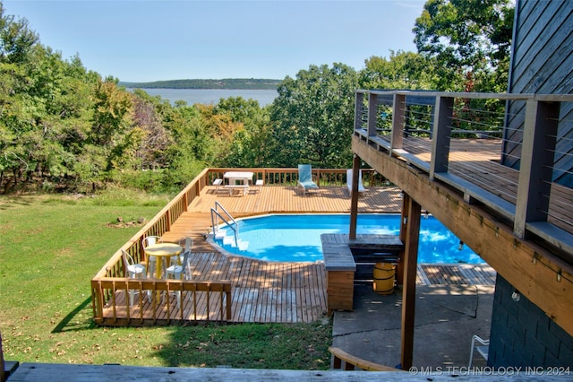 view of swimming pool with a lawn and a deck with water view