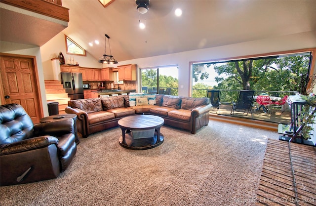 living room featuring light carpet, high vaulted ceiling, and ceiling fan