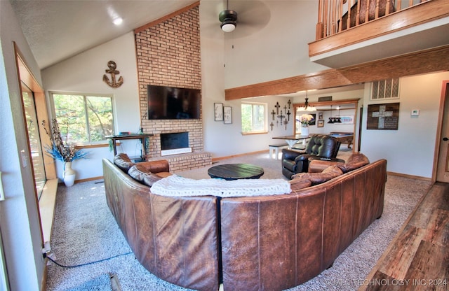 living room featuring high vaulted ceiling, a brick fireplace, ceiling fan, and hardwood / wood-style flooring