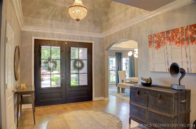 entryway with french doors, light hardwood / wood-style floors, a notable chandelier, and a healthy amount of sunlight