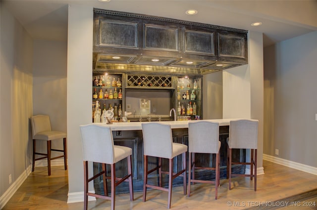 bar featuring wood-type flooring and sink