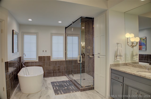 bathroom with vanity, tile walls, and plus walk in shower