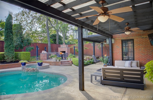 view of swimming pool featuring ceiling fan, a patio, an outdoor living space with a fireplace, and a pergola