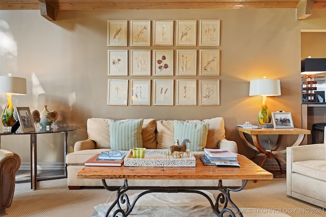 carpeted living room featuring beamed ceiling