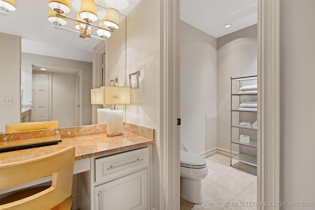 bathroom with tile patterned flooring, toilet, a chandelier, and vanity